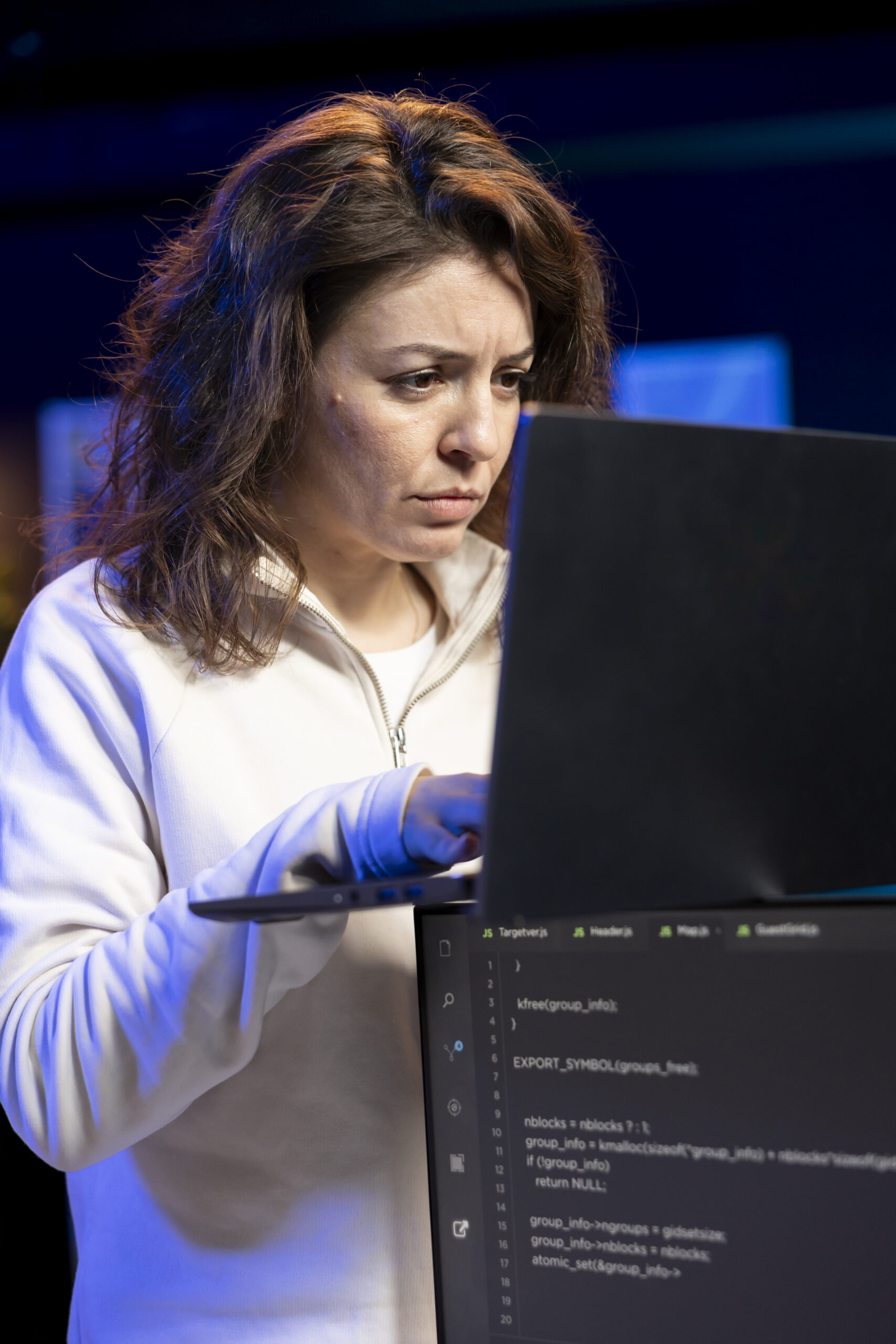 Programmer typing on laptop keyboard, testing and debugging